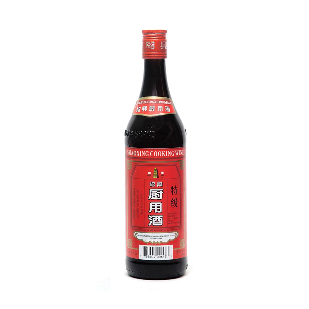 A tall bottle of black cooking wine with red label and cap